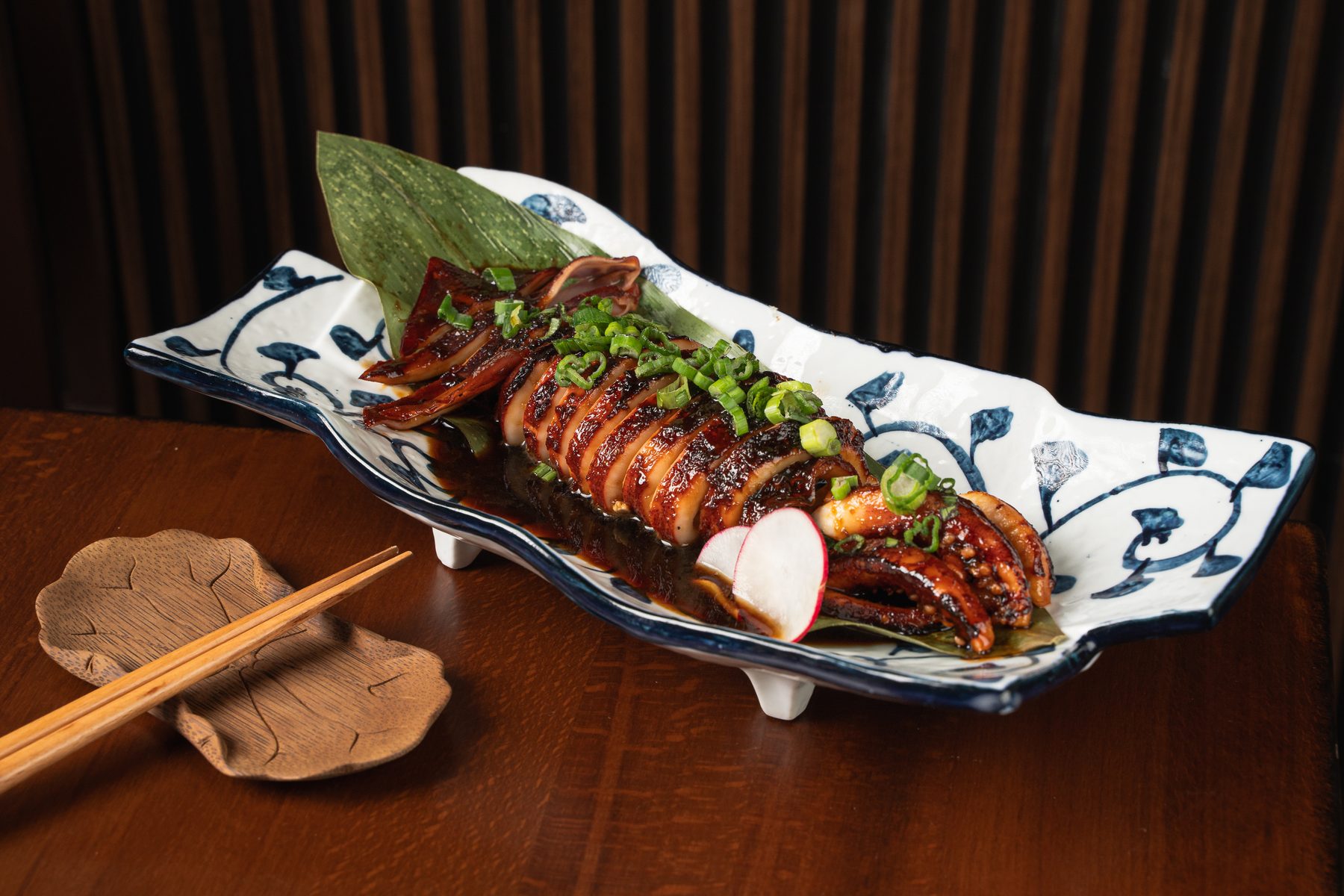 Ika-Sugata at Izakaya Nana in Chantilly, VA: a whole teriyaki-glazed squid sliced into rings with scallions on a blue-and-white platter