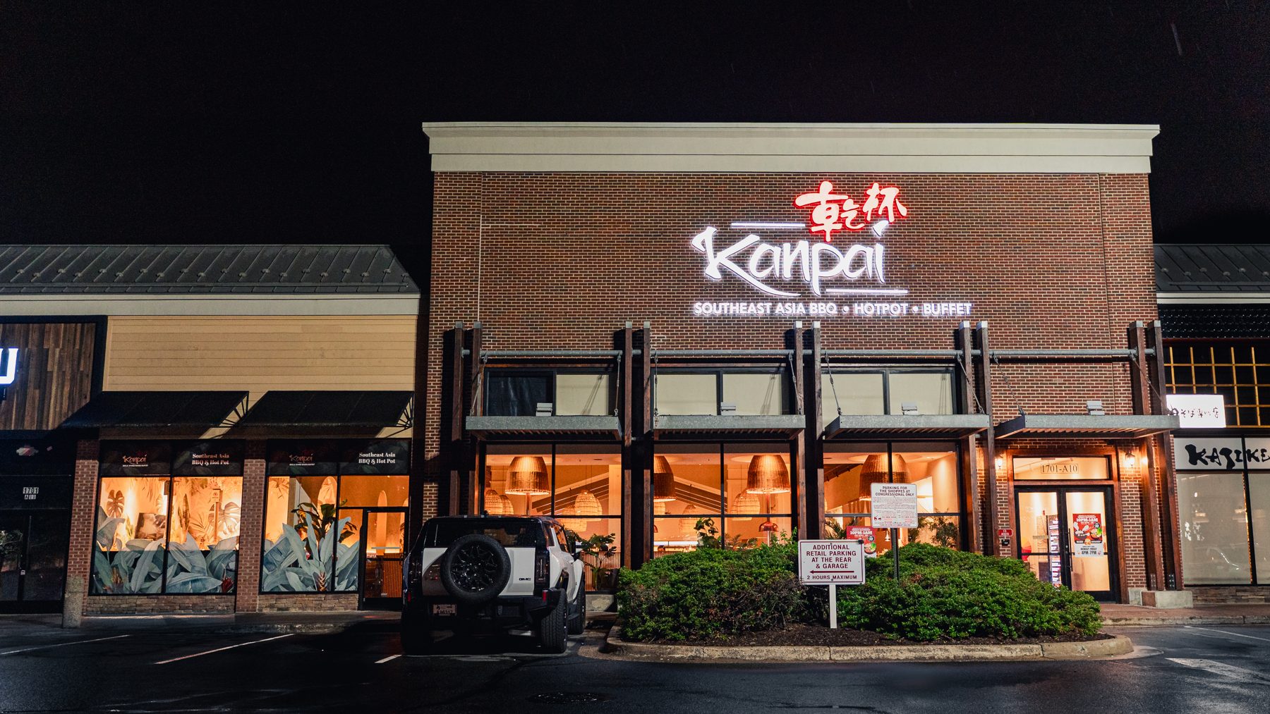 Kanpai BBQ & Hotpot's lit storefront at night in The Shops at Congressional Village